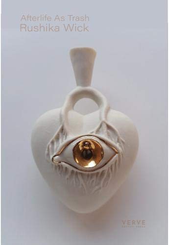 Book cover: white ceramic heart with a golden eye detail.