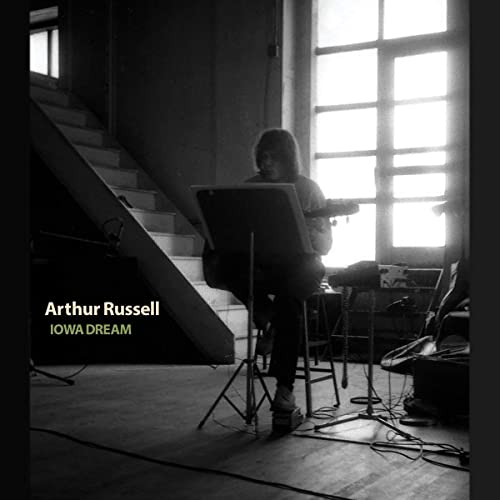 Black and white album cover featuring a person with a cello on stairs.