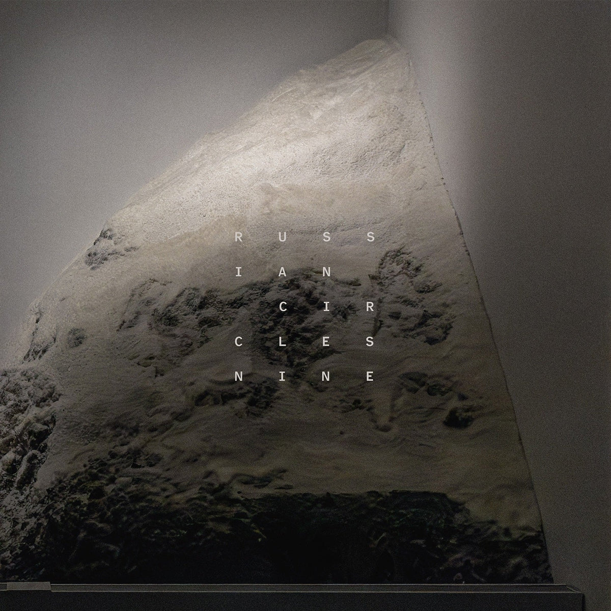 Album cover for Russian Circles’ “Nine” featuring a textured, grayscale landscape.