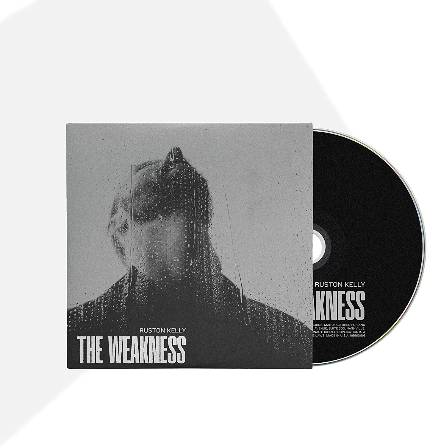"CD case with a black and white cover and a black disc."