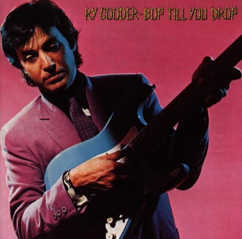 Ry Cooder in a purple suit playing an electric guitar against a pink background.