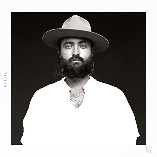 Black and white portrait of Ry X wearing a hat and beard.