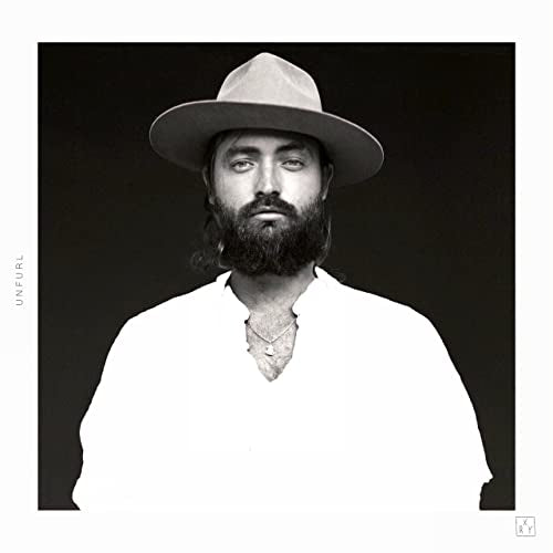 Black and white portrait of RY X wearing a hat and beard.