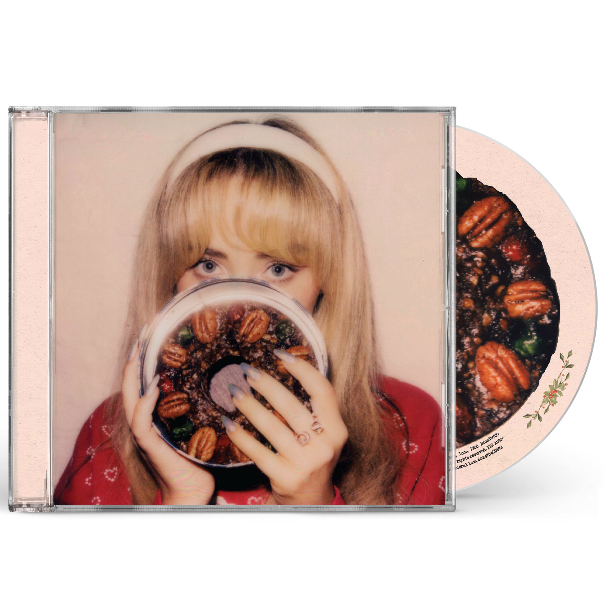 Sabrina Carpenter holding a fruitcake in front of her face on a CD case.