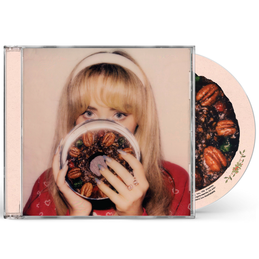 Sabrina Carpenter holding a fruitcake in front of her face on a CD case.