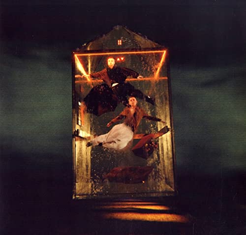Two figures inside a glowing, geometric house-shaped structure.