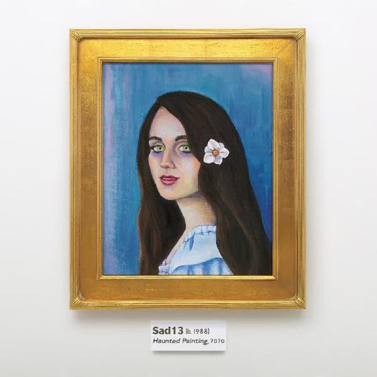 Gold-framed portrait of a woman with dark hair and a white flower.