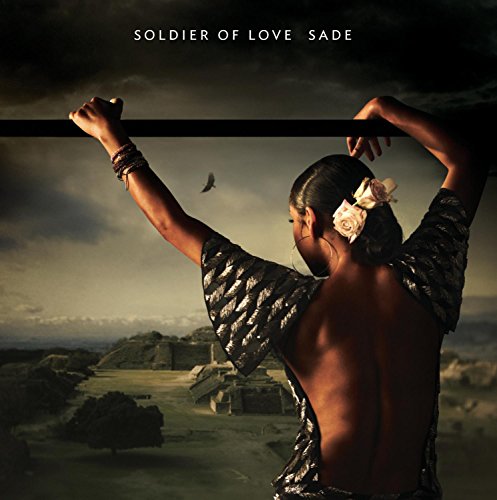 Sade album cover: woman with raised arms against a cloudy sky.