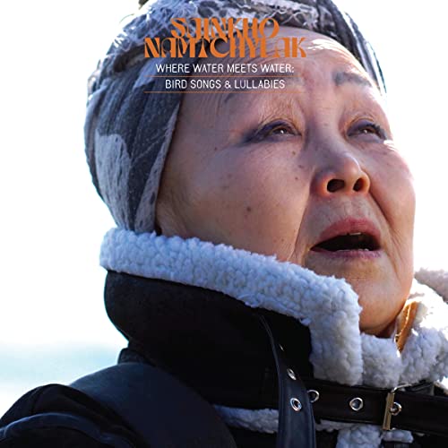 Close-up of Sainkho Namtchylak singing, wearing a winter hat and coat.