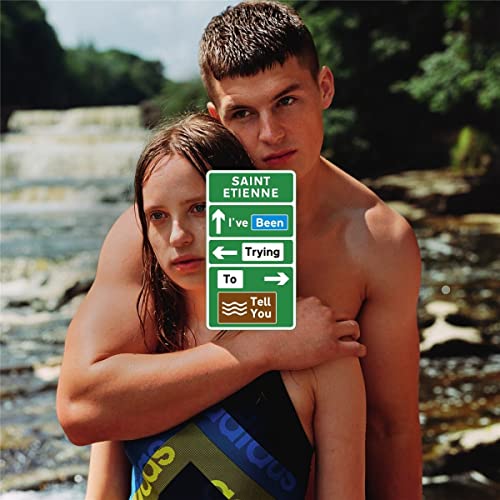 A young man and woman embrace in front of a waterfall, overlaid with road signs.
