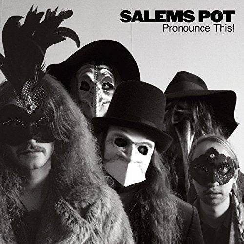 Black and white photo of four masked figures wearing hats.