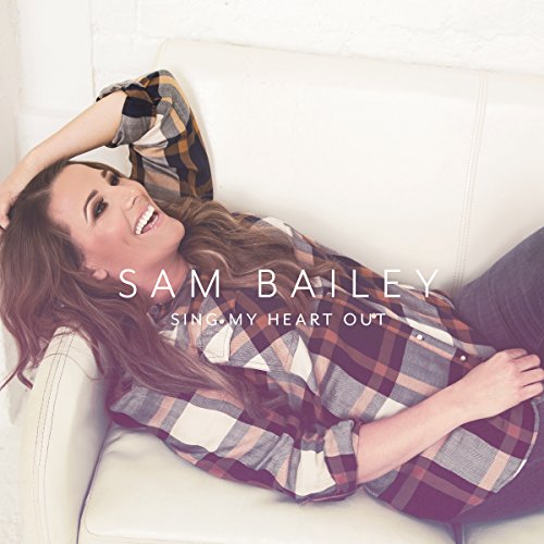 "Album cover featuring a smiling woman lying down, wearing a plaid shirt."