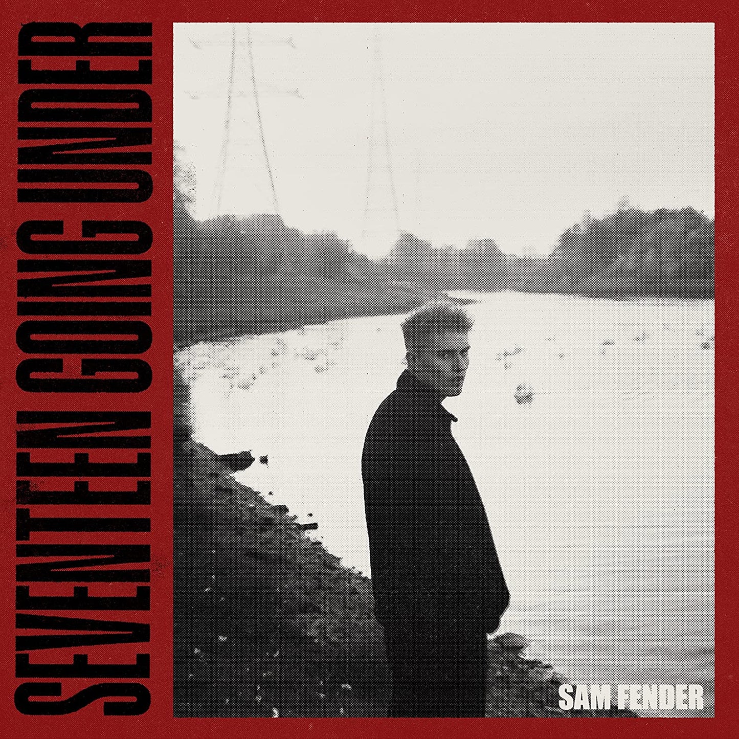 Album cover: Sam Fender stands by a riverbank, black and white photo.