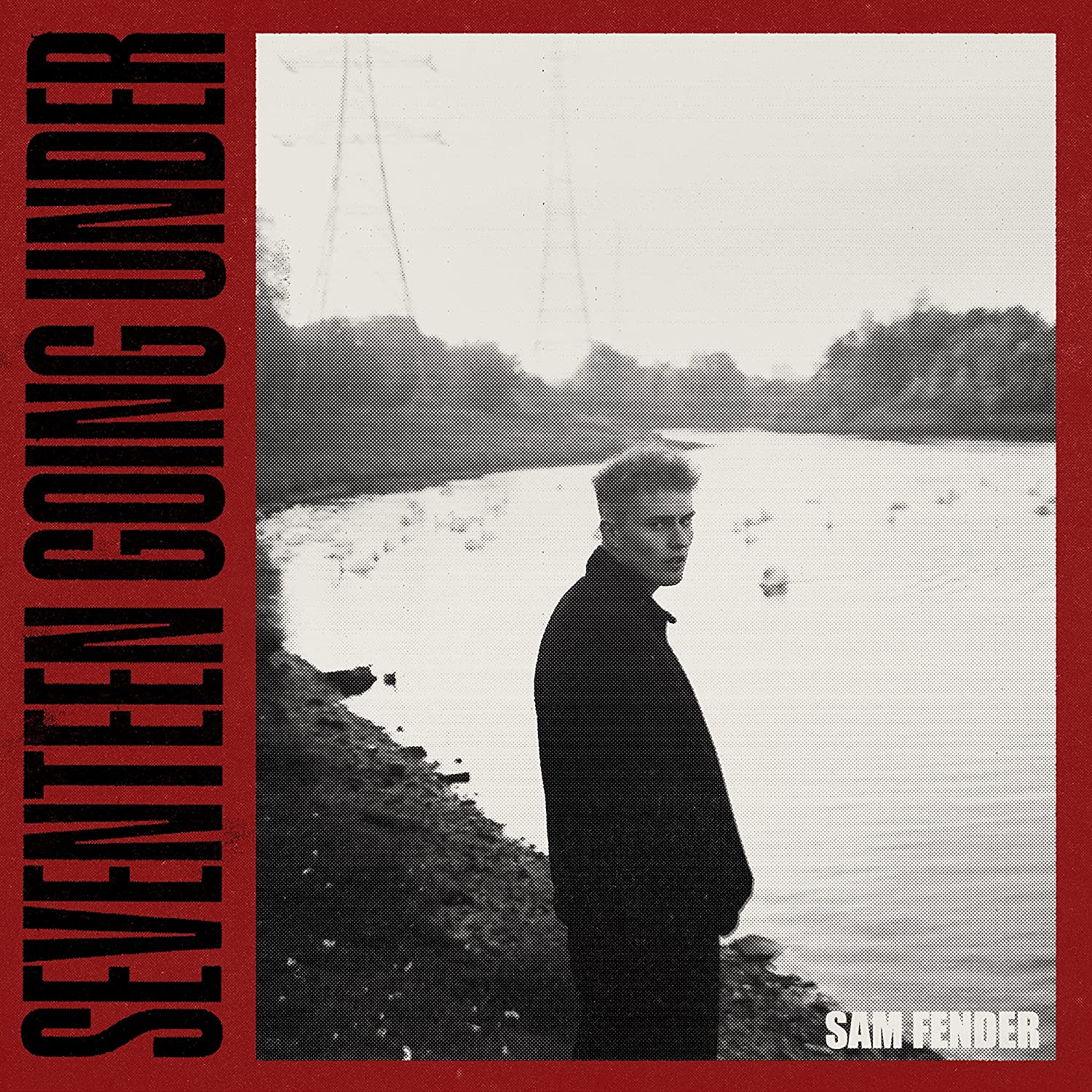 Album cover: Sam Fender stands by a riverbank, black and white photo.