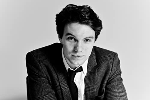 Black and white portrait of a young man in a suit and bow tie.