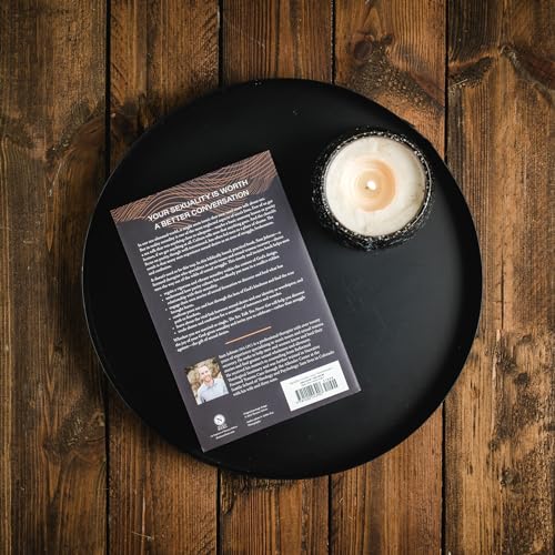 Book back cover and lit candle on a dark, round tray.
