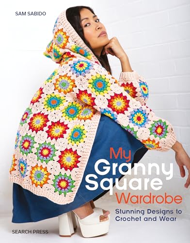 A person wearing a colorful crochet granny square hooded cardigan over a blue dress.