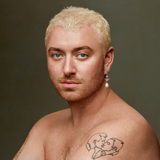 Sam Smith portrait, blonde hair, bare chest, and facial tattoos.