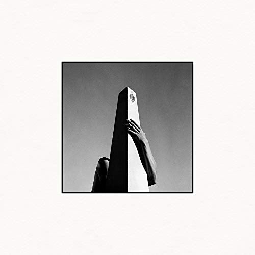 Black and white album cover featuring a hand touching a monolith.
