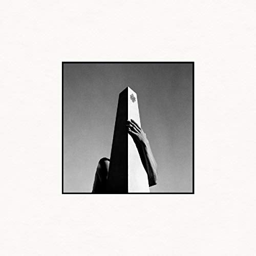 Black and white album cover featuring a hand on a tall monolith.