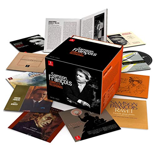 "Black and orange box set with various CDs and booklets scattered around it."