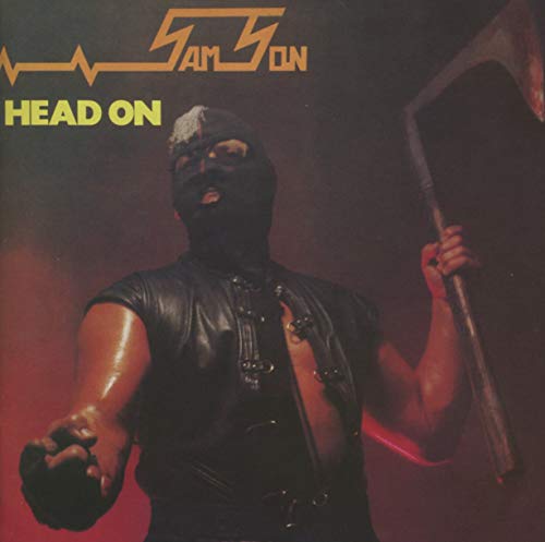 A man in a black leather mask and vest holds an axe on stage.