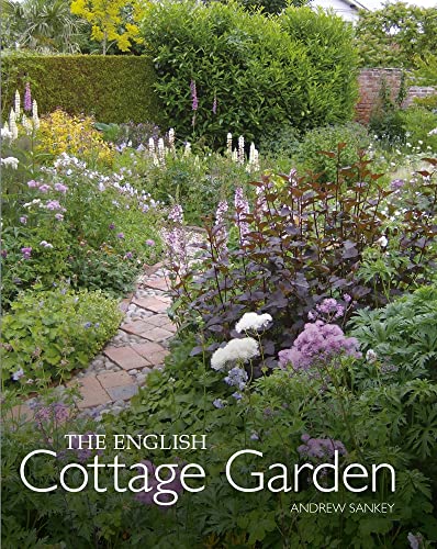 A stone path winds through a lush English garden filled with various colorful flowers.