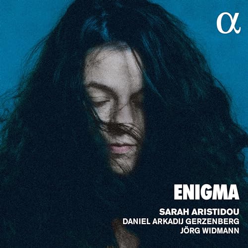 Album cover featuringBLue background with a woman's face partially obscured by dark hair.