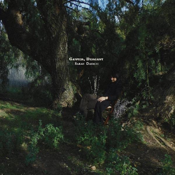 Album cover: woman seated beneath a tree in a landscape.