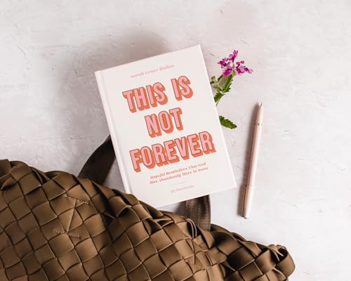 White devotional book with red title, pen, and flowers on textured surface.