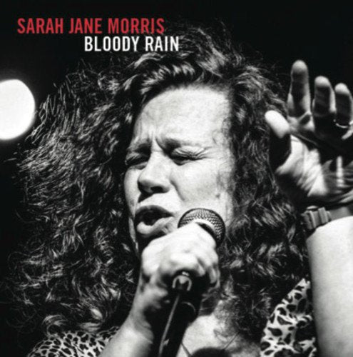 Black and white image of a woman singing into a microphone, with red and white text.