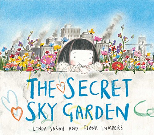 A young girl with dark hair peeks over a wall filled with colorful flowers.