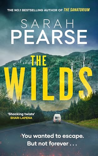 Book cover for "The Wilds" with mountains, a road, and a van.