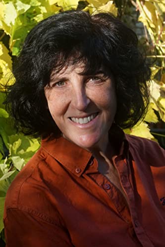 Headshot of author, smiling woman with dark curly hair, outdoors.