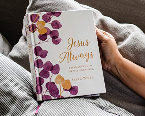 White devotional book with floral cover resting on a gray blanket.