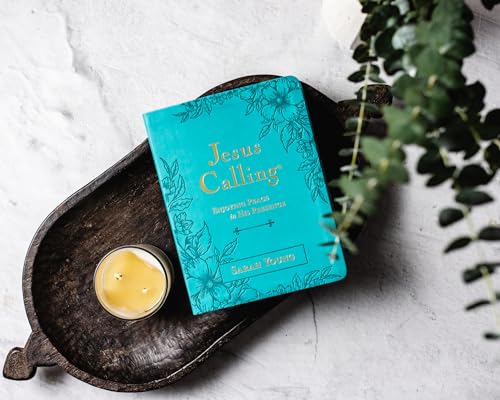 Teal devotional book, “Jesus Calling,” with a lit candle nearby.