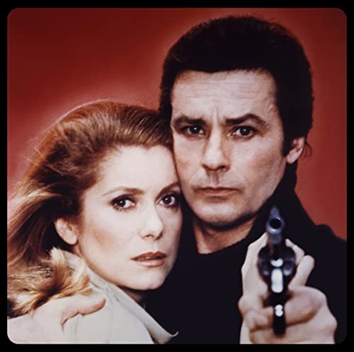 Close-up of a man and woman with a handgun in the foreground.