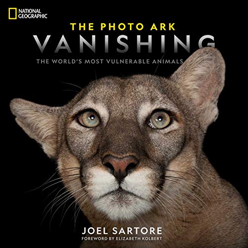 Close-up of a cougar's face on the cover of a National Geographic book.
