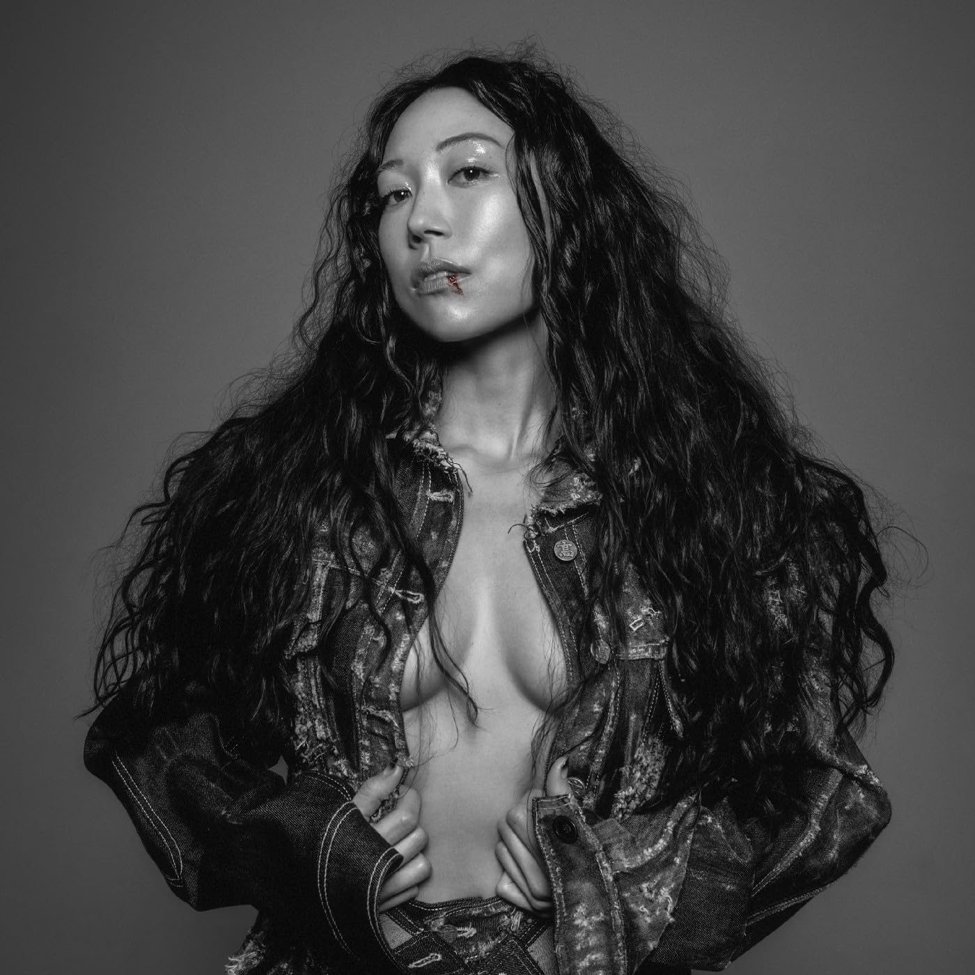 Black and white portrait of Sasami with long hair and a denim jacket.