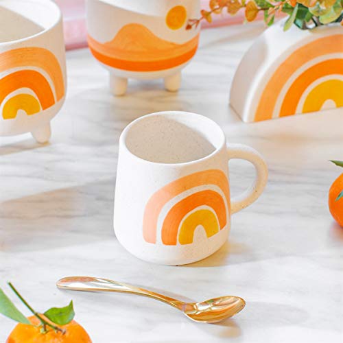 White ceramic mug with a colorful, painted rainbow design.