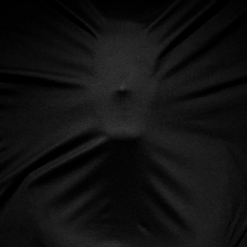 Black fabric draped to suggest a distorted human form.