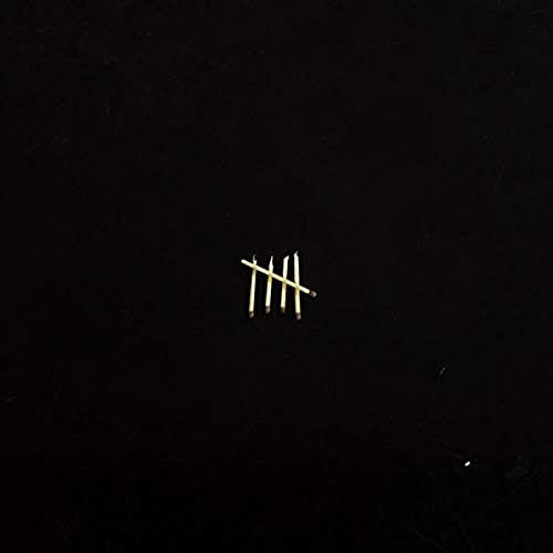 Five matchsticks arranged as a tally mark on a solid black background.