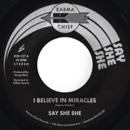 Black and white vinyl record label with text: "Say She She - I Believe In Miracles".