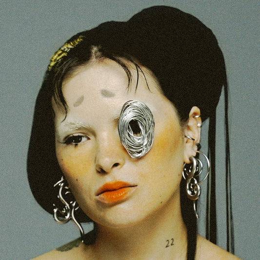 Close-up portrait of a woman with striking silver facial adornments.