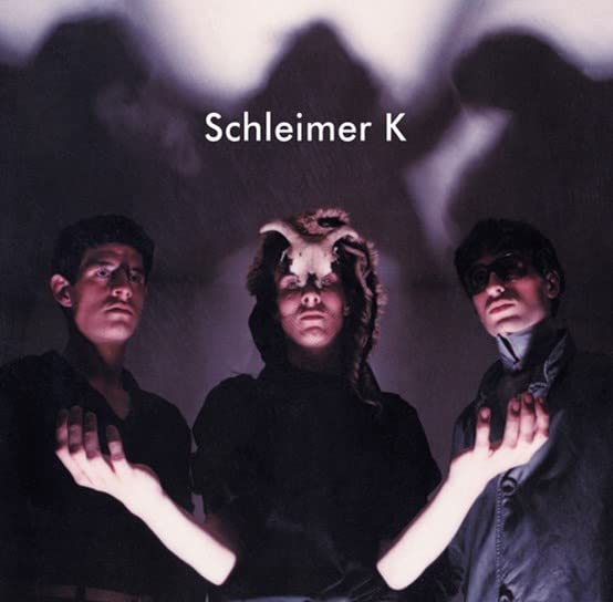 Schleimer K album cover with three figures in dark clothing.