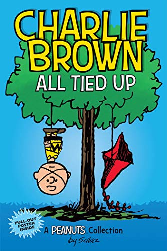 Charlie Brown hangs upside down from a tree next to a tangled red kite.
