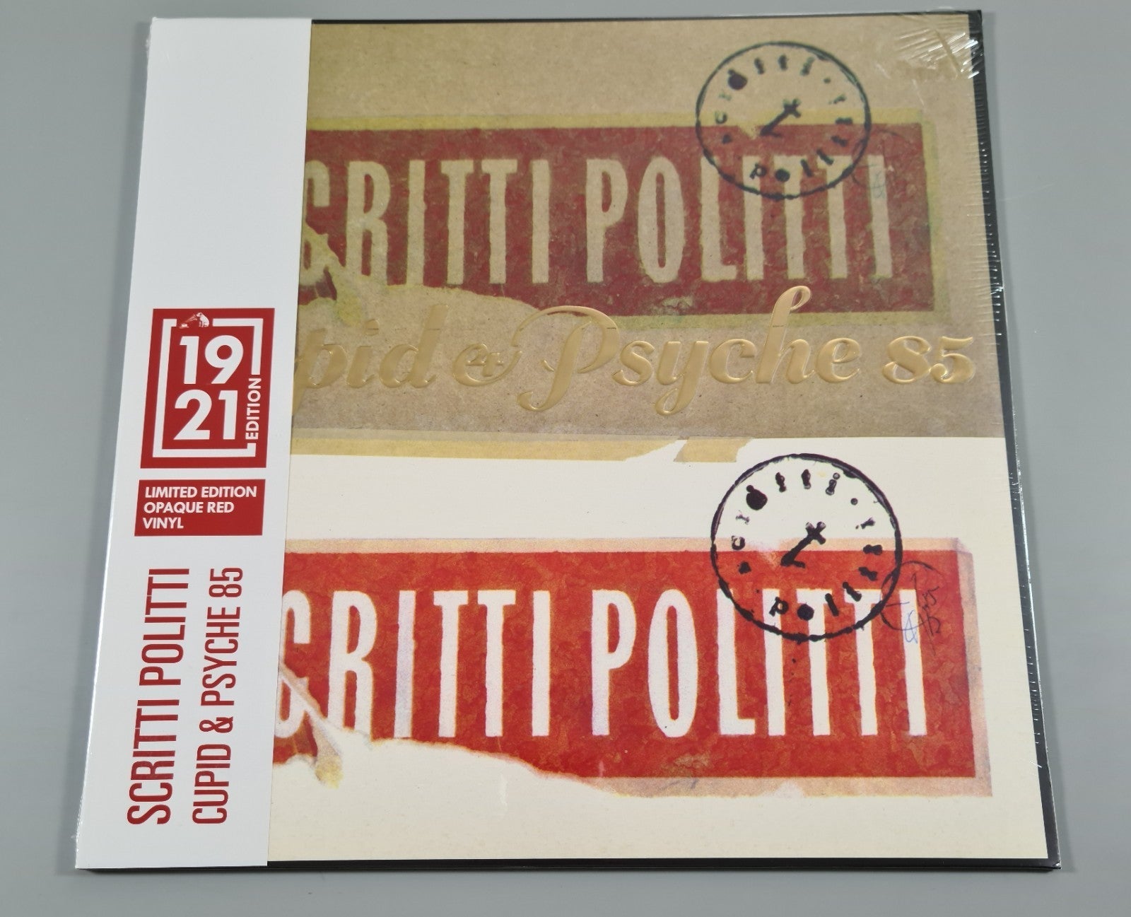 Scritti Politti" album cover with clocks and red, gold, and beige tones.