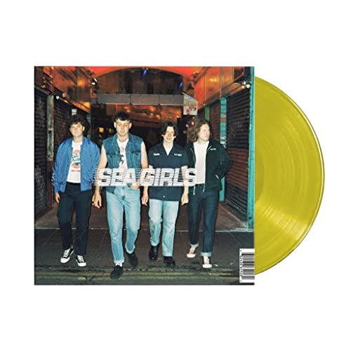 Three men standing in an alleyway next to a yellow vinyl record.