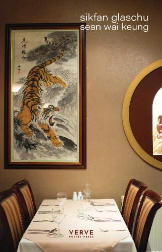 Book cover with a tiger painting hangs above a set dining table.