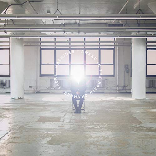 Person meditating in a bright, industrial room with large windows.